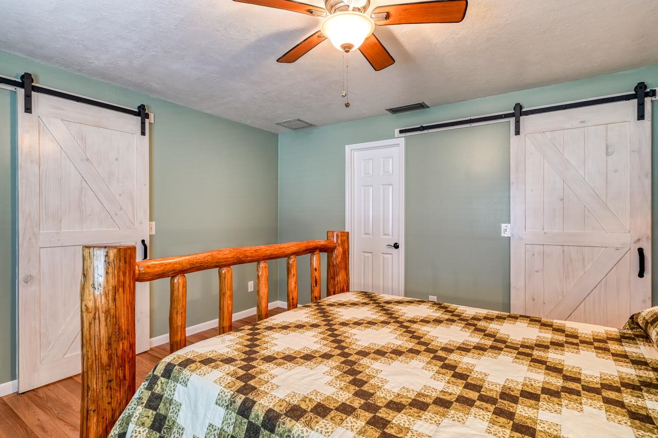 336 Lobelia Road St. Augustine, FL 32086 - Photo 28 of 46 a bedroom with a bed and a chandelier
