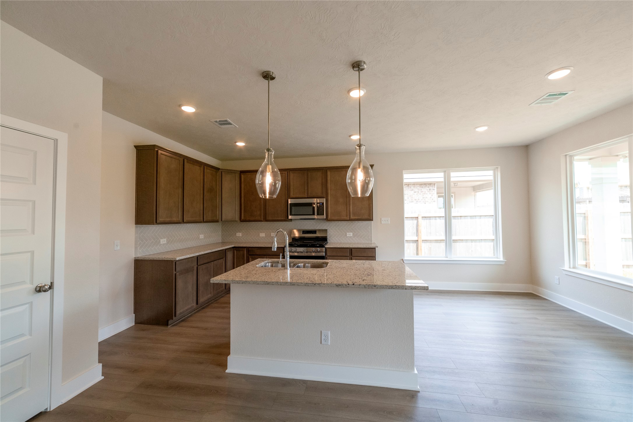 2051 Winepress Road Brenham, TX 77833 - Photo 20 of 31 a large kitchen with stainless steel appliances a large counter top a sink and a window
