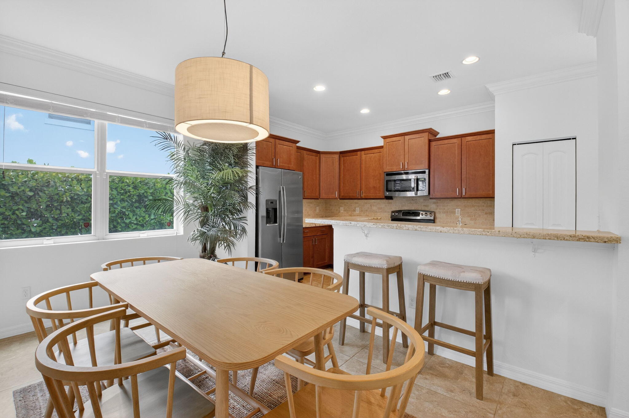 3630 Wolf Run Lane Boynton Beach, FL 33435 - Photo 17 of 59 a kitchen with stainless steel appliances granite countertop a stove a refrigerator a kitchen island a table and chairs