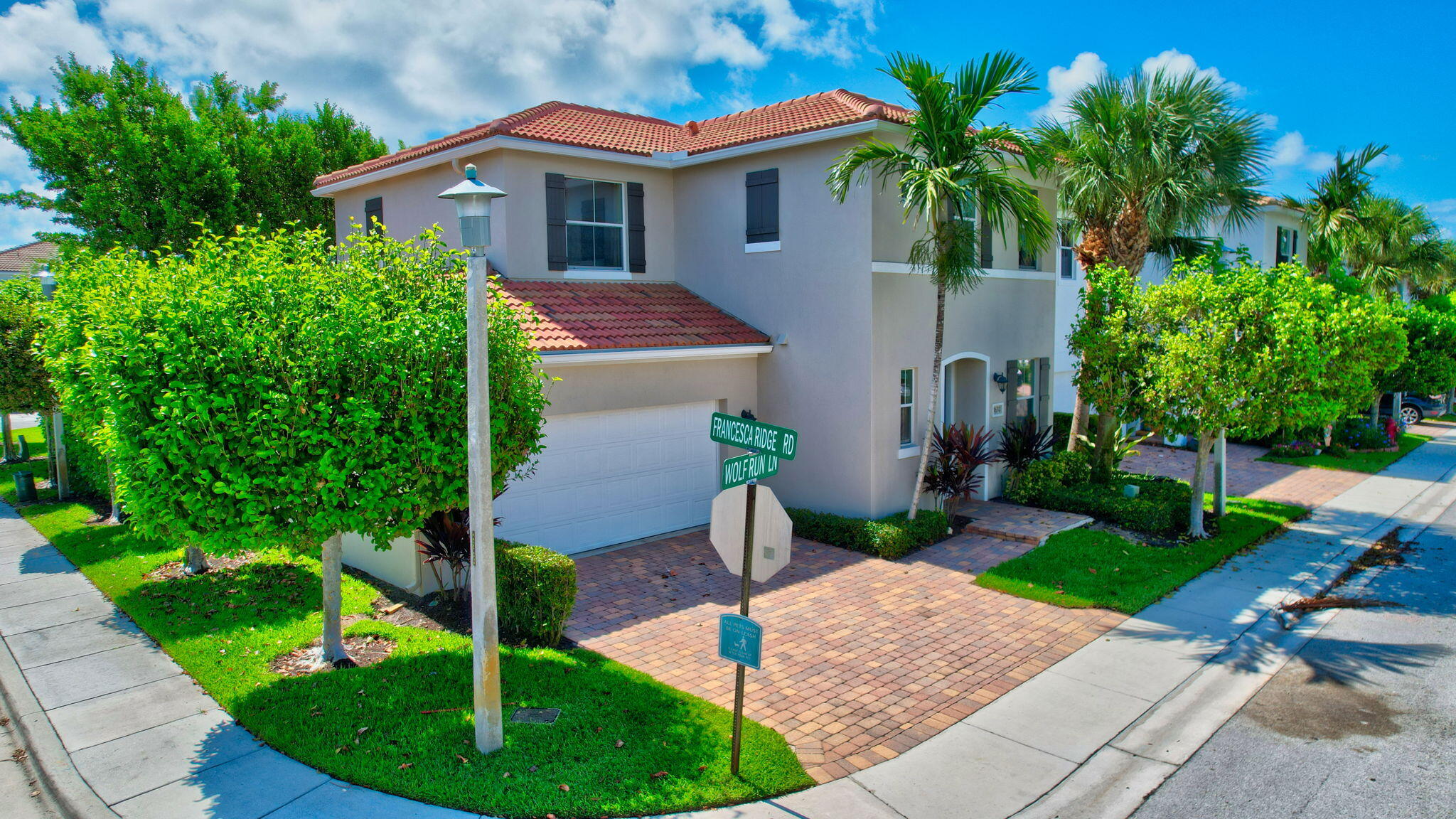 3630 Wolf Run Lane Boynton Beach, FL 33435 - Photo 47 of 59 a front view of a house with a yard and potted plants