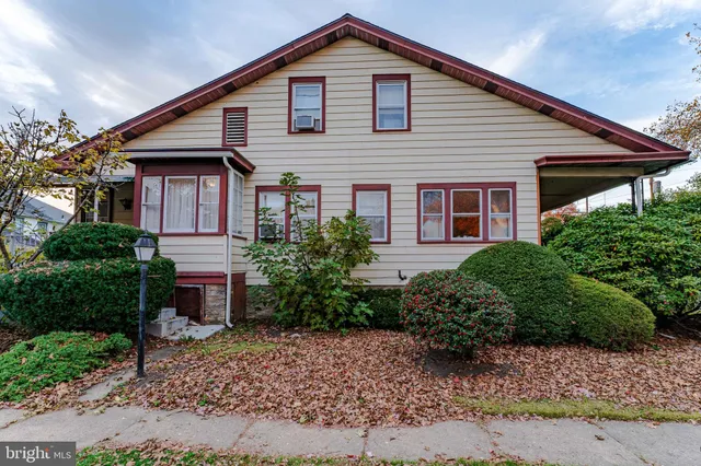 a front view of a house with a yard and potted plants