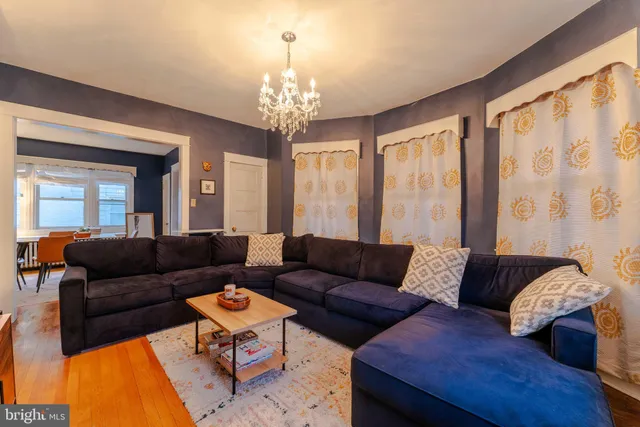 a living room with furniture and a chandelier