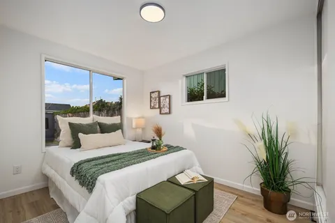 a bedroom with a large bed and a potted plant