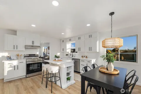a kitchen with refrigerator cabinets dining table and chairs