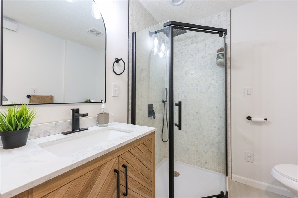 6 Matthew Lane Chelmsford, MA 01824 - Photo 15 of 37 a bathroom with a granite countertop sink vanity mirror and shower