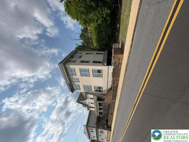 581 Mauch Chunk Road Palmerton, PA 18071 - Photo 2 of 27 A multi-story exterior features classic siding alongside a paved roadside curb.