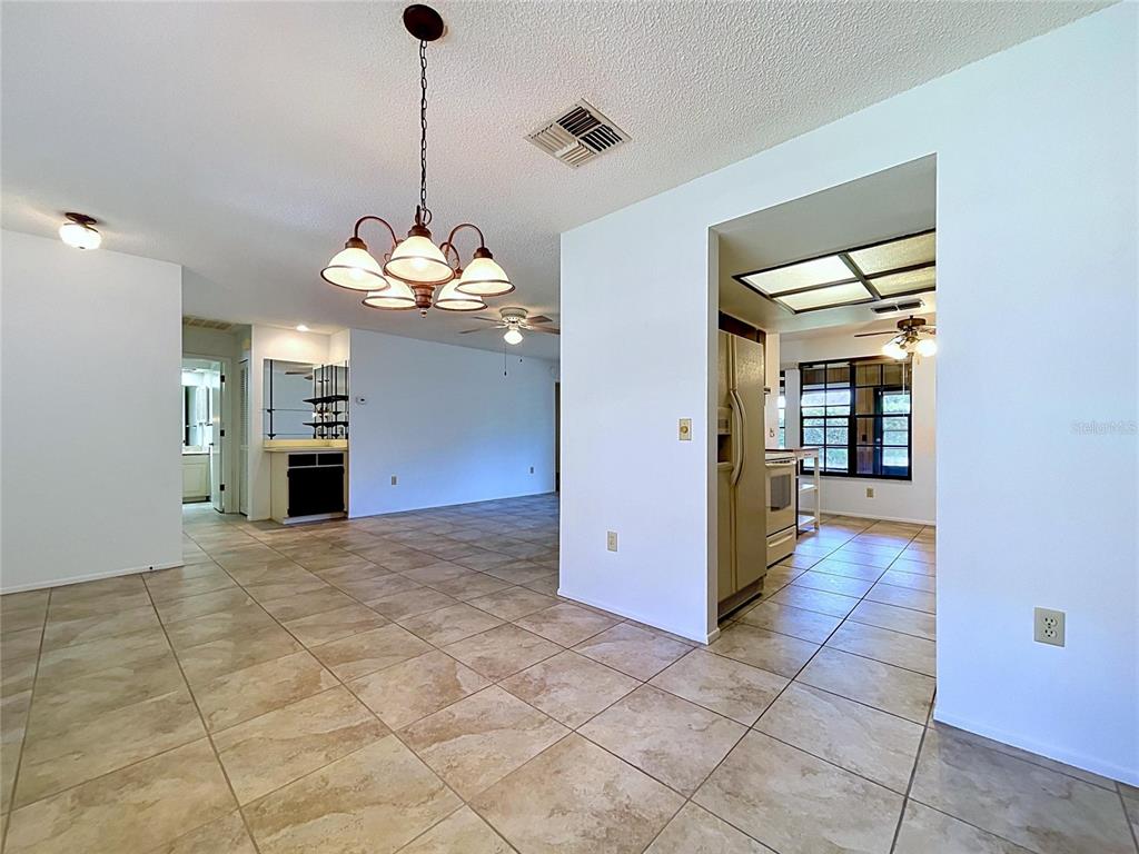 9319 Trowbridge Court New Port Richey, FL 34655 - Photo 22 of 78 a view of a hallway with wooden floor and a kitchen