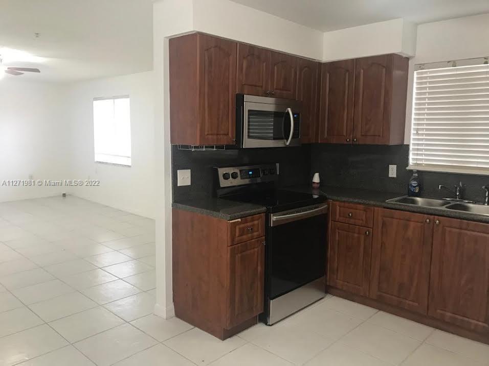 1453 Southwest 3rd Street, Unit 205 Miami, FL 33135 - Photo 3 of 9 a kitchen with stainless steel appliances granite countertop a refrigerator and a stove top oven