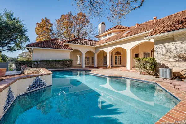 a view of a house with pool and chairs