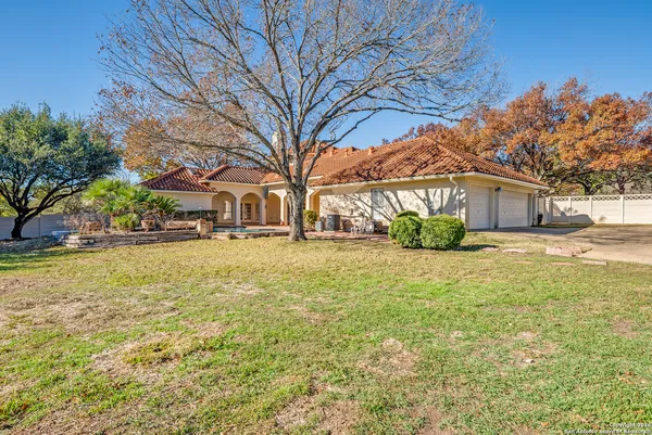 a front view of a house with a yard and trees
