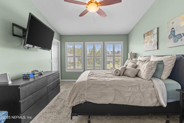 a spacious bedroom with a bed and a flat screen tv