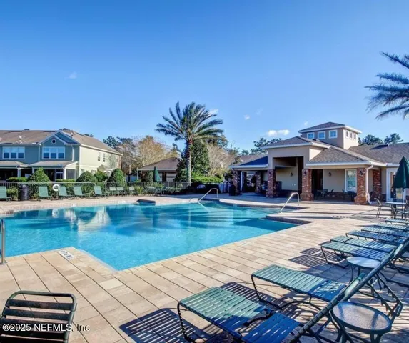 a view of a house with pool and chairs