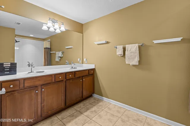 a spacious bathroom with a double vanity sink and a mirror