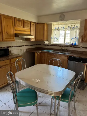 a kitchen with a table chairs a sink dishwasher window and cabinets