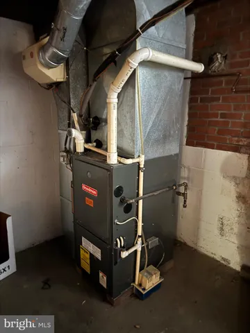 a room with water heater and wooden cabinets