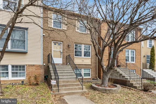 a front view of a house with a tree