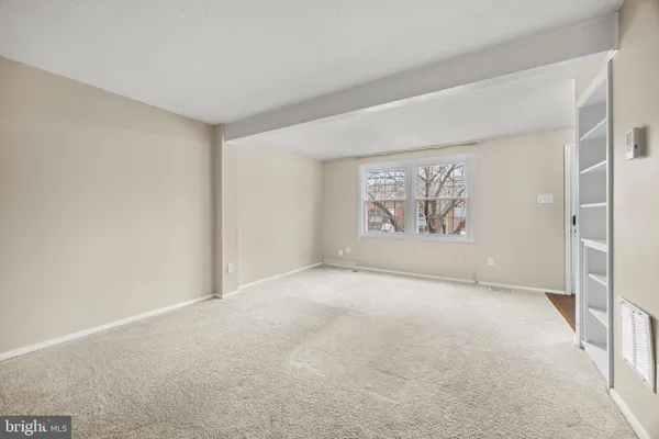 a view of an empty room with a window and closet