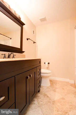 a bathroom with a sink a toilet and mirror