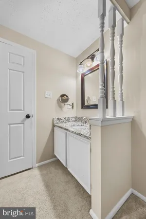 a bathroom with a granite countertop sink and a mirror