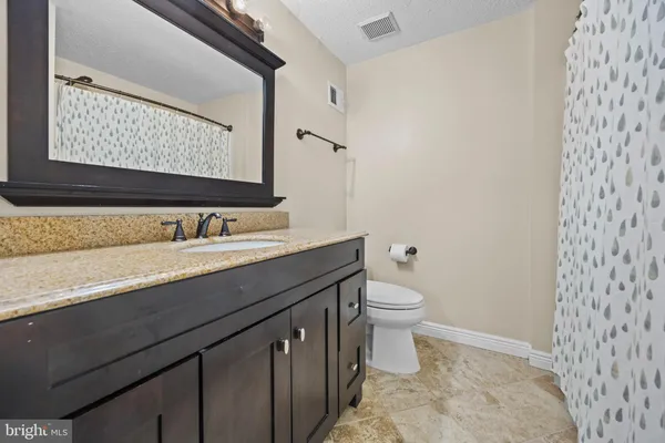 a bathroom with a double vanity sink toilet and a mirror