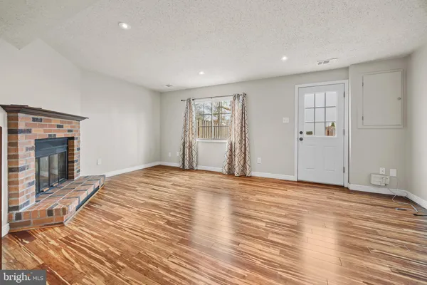 a view of empty room with wooden floor and fireplace
