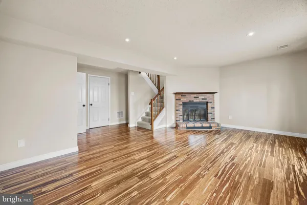 a view of empty room with wooden floor and fireplace