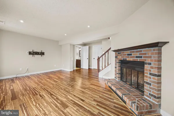 a view of empty room with wooden floor and fireplace