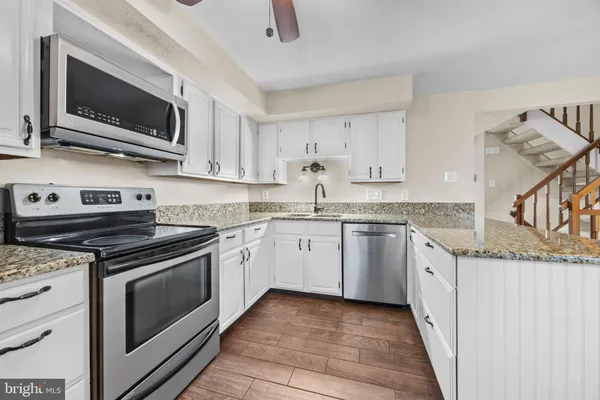 a kitchen with granite countertop cabinets stainless steel appliances and a sink