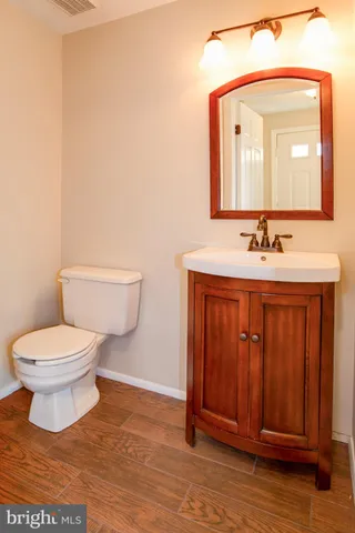 a bathroom with a toilet a sink and mirror