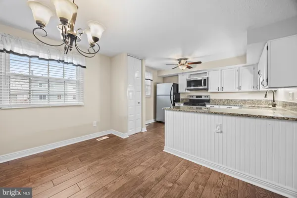 a kitchen with a refrigerator cabinets and wooden floor