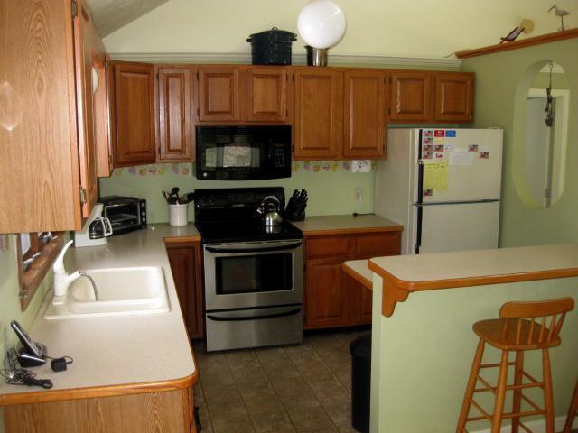 380 Governor Prence Road Eastham, MA 02642 - Photo 16 of 28 a kitchen with a sink a refrigerator and a stove top oven
