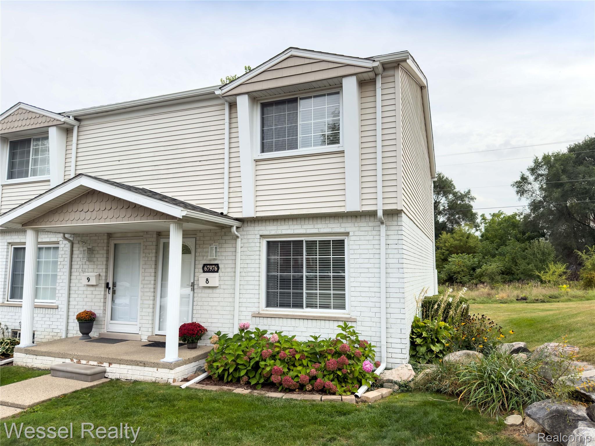 67976 Van Dyke Road, Unit 8 Washington, MI 48095 - Photo 3 of 27 Colonial-style house with a front lawn and brick siding