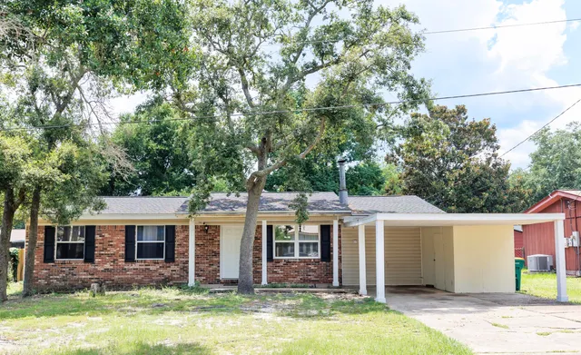 a front view of house with yard and trees in the background