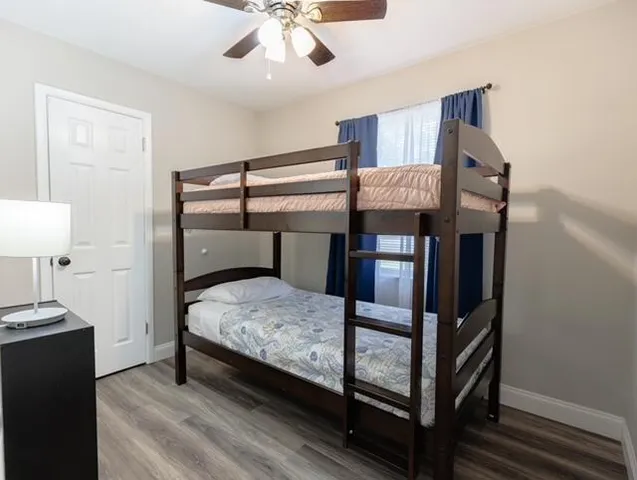 a bedroom with a bed wooden floor and window