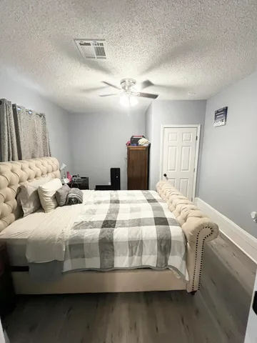 a bedroom with a bed and wooden floor