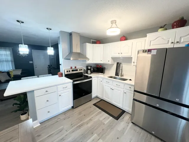 a kitchen with white cabinets and white appliances
