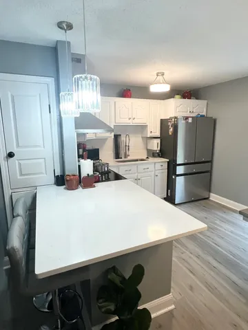 a kitchen with kitchen island a stove a refrigerator and a chandelier