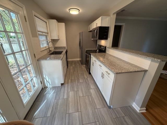 1219 South White Station Road Memphis, TN 38117 - Photo 7 of 18 a kitchen with a sink a wooden floor and a large window