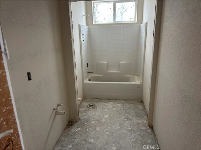 a bathroom with a bathtub toilet and window