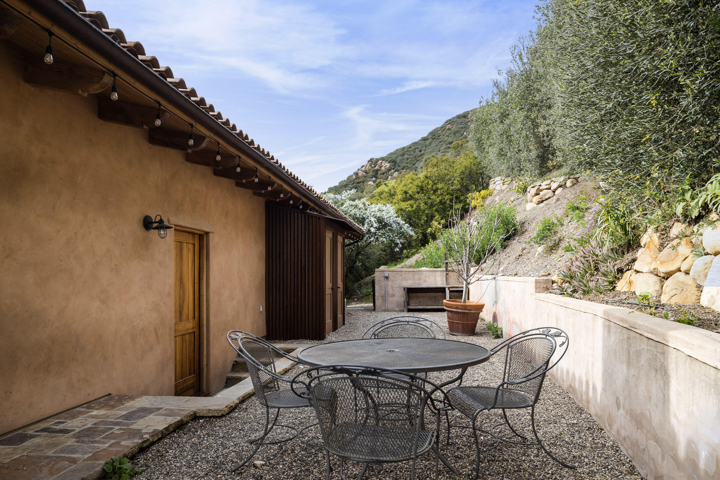 356 East Mountain Drive Montecito, CA 93108 - Photo 22 of 36 a view of a backyard with table and chairs with wooden floor and fence