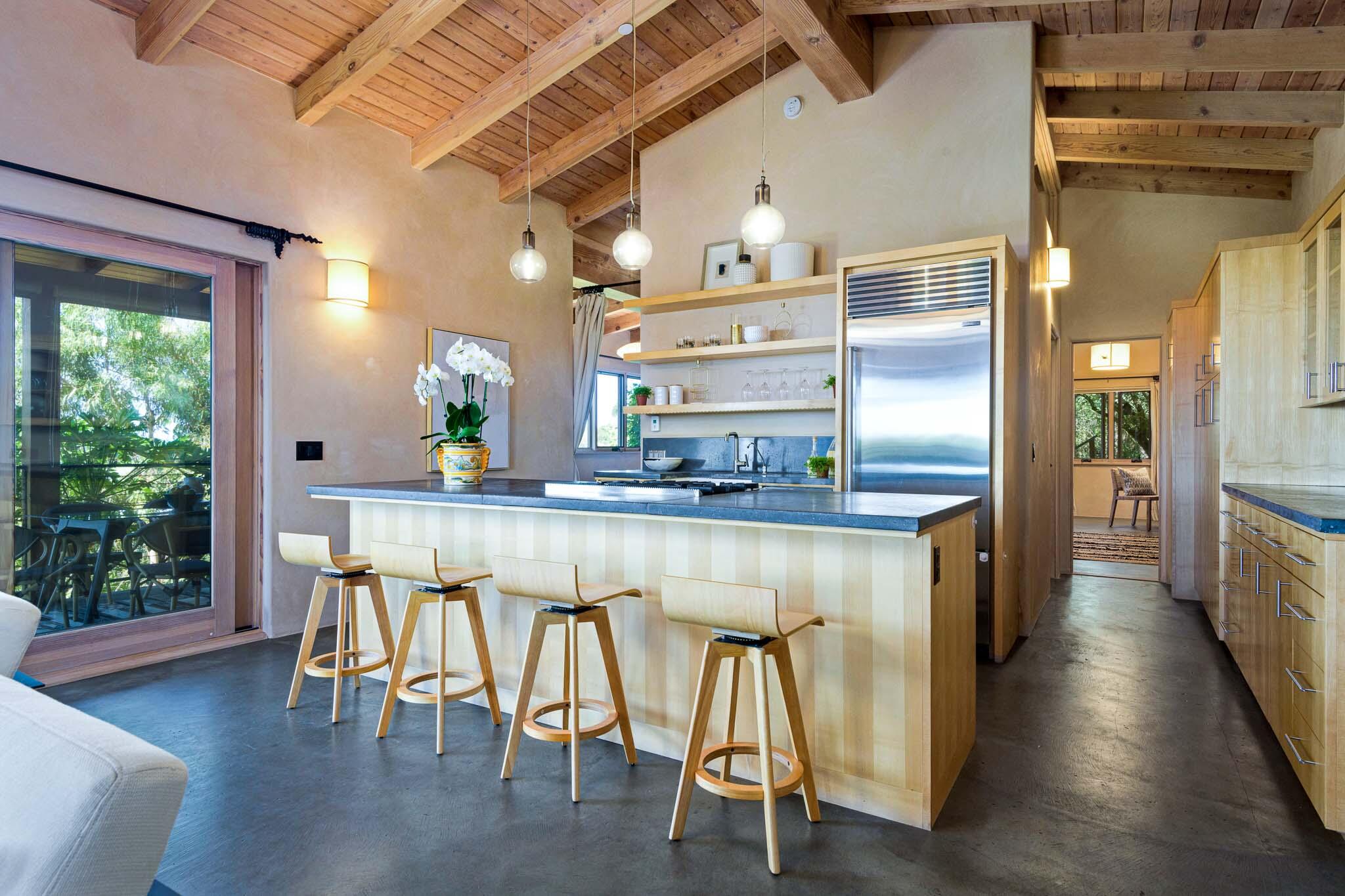 356 East Mountain Drive Montecito, CA 93108 - Photo 7 of 36 a kitchen with stainless steel appliances granite countertop a table chairs in it and wooden floors