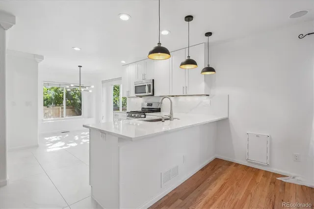a kitchen with kitchen island a sink stainless steel appliances and cabinets