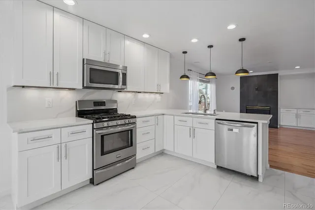 a kitchen with white cabinets and stainless steel appliances