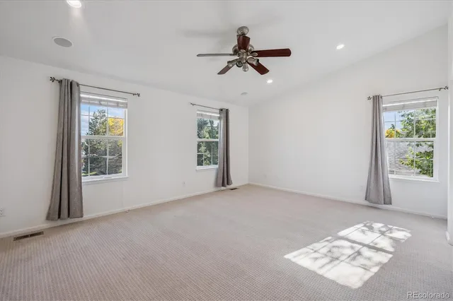 a view of a big room with windows and chandelier fan