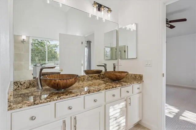 a bathroom with a granite countertop sink and a mirror