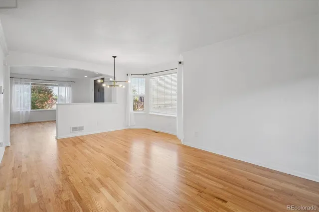 a view of empty room with wooden floor and window