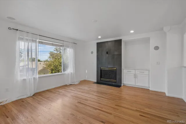 a view of empty room with wooden floor and fireplace