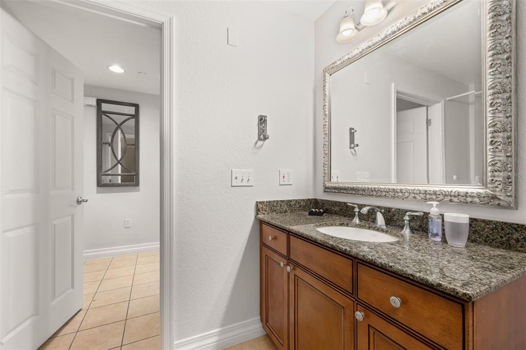 1100 Sunset View Circle, Unit 302 Reunion, FL 34747 - Photo 12 of 56 a bathroom with a granite countertop sink and a mirror