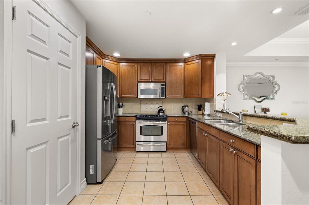 1100 Sunset View Circle, Unit 302 Reunion, FL 34747 - Photo 13 of 56 a kitchen with stainless steel appliances granite countertop a refrigerator and a sink