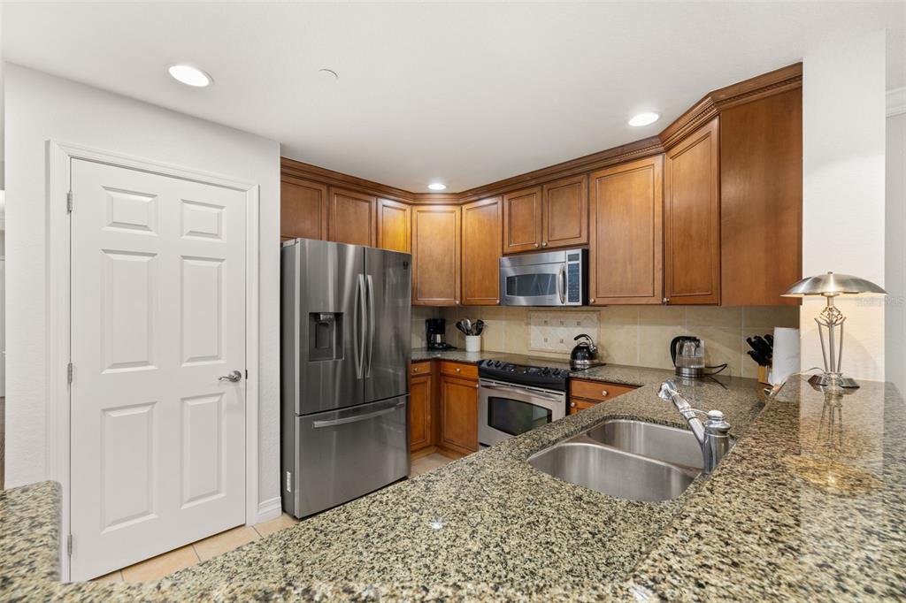 1100 Sunset View Circle, Unit 302 Reunion, FL 34747 - Photo 14 of 56 a kitchen with stainless steel appliances granite countertop a refrigerator sink and stove
